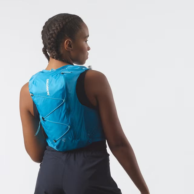 Person wearing a blue running vest on a plain background